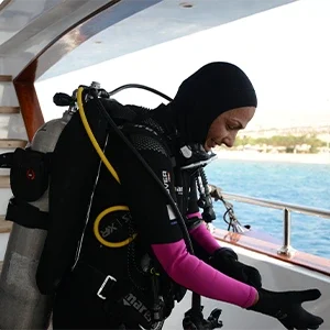 Female diver preparing her gear on a boat for a professional PADI scuba diving course in Aqaba